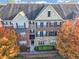 Exterior aerial shows well-maintained four-story townhome with brick, stone and vinyl siding, complemented by mature trees at 1222 Poston Se Pl, Smyrna, GA 30080