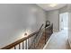 Hallway featuring carpet flooring, wooden railing, and stylish sconce lighting at 1222 Poston Se Pl, Smyrna, GA 30080