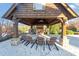 Cozy outdoor seating area under a wooden pavilion with a fireplace and mounted ceiling fan at 1222 Poston Se Pl, Smyrna, GA 30080