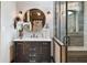 An elegant bathroom featuring a black vanity, custom tilework, accent lighting, and a walk-in shower at 1694 Mount Bethel Rd, Mcdonough, GA 30252