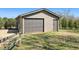 Garage with neutral siding, a rolling garage door, and an adjacent door at 1694 Mount Bethel Rd, Mcdonough, GA 30252