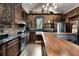 Beautiful kitchen featuring brick walls, custom cabinets, stainless steel appliances, and wood countertops at 1694 Mount Bethel Rd, Mcdonough, GA 30252