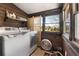 Laundry room with washer and dryer, wood paneling, and a bright window at 1694 Mount Bethel Rd, Mcdonough, GA 30252