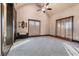 Spacious main bedroom featuring neutral carpet, ceiling fan, bench seat, and plenty of natural light from two windows at 1694 Mount Bethel Rd, Mcdonough, GA 30252