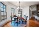 Cozy dining area with round table, chandelier, and large windows with wooded views at 268 Hanson Way, Marietta, GA 30064