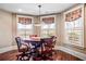 Cozy game room featuring wood floors, a wooden game table with seating, and windows with stylish patterned window treatments at 268 Hanson Way, Marietta, GA 30064
