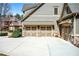 Attached three-car garage with carriage-style doors, stone accents, and a spacious concrete driveway at 268 Hanson Way, Marietta, GA 30064