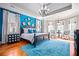 Bright main bedroom boasts a tray ceiling, large windows, a blue accent wall, and wood floors at 268 Hanson Way, Marietta, GA 30064