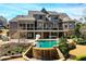 Beautiful backyard with a multi-tiered pool, waterfall feature, covered patio and ample seating at 268 Hanson Way, Marietta, GA 30064