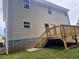 Exterior side view of the home, showing a wooden deck overlooking the green backyard at 309 Melanie Ct, Bowdon, GA 30108