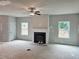 Spacious living room featuring a modern fireplace, ceiling fan, and two large windows at 309 Melanie Ct, Bowdon, GA 30108