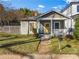 Quaint home featuring a yellow front door, covered porch, and a well-maintained lawn at 1050 Boulevard Ne Dr, Atlanta, GA 30317