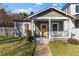 Charming bungalow with a welcoming front porch, swing, and a bright yellow front door at 1050 Boulevard Ne Dr, Atlanta, GA 30317