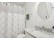 Cozy bathroom featuring a marble vanity, round mirror, and shower with coral patterned curtain at 213 Oak Ln, Decatur, GA 30030