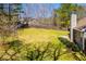 A sprawling, grassy backyard with mature trees and a wood privacy fence at 314 Meadow Spring Dr, Temple, GA 30179