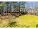 A large grassy backyard with mature trees and a shed along a wood fence at 314 Meadow Spring Dr, Temple, GA 30179