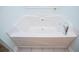 Large bathtub in the bathroom with chrome fixtures and tile flooring at 314 Meadow Spring Dr, Temple, GA 30179