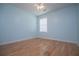 Light blue bedroom with wood flooring and a large window at 314 Meadow Spring Dr, Temple, GA 30179