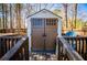 A well-maintained shed with double doors and a deck in a fenced-in backyard at 314 Meadow Spring Dr, Temple, GA 30179