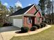 A well-maintained home featuring a brick facade, black shutters, and an attached two-car garage at 401 Carrie Kathleen Ter, Carrollton, GA 30116