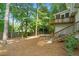 Backyard view with a deck, stairs, lush trees, a wooden fence, and a fire pit area at 4956 Braeburn Nw Trce, Acworth, GA 30102