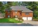 Charming brick home with a well-manicured lawn and a two-car garage nestled among lush trees at 4956 Braeburn Nw Trce, Acworth, GA 30102