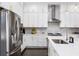 Modern kitchen with stainless steel appliances, bright white cabinets, quartz countertops, and stylish pendant lighting at 6616 Aria Village Dr, Atlanta, GA 30328