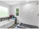 Bathroom with a soaking tub, subway tile shower, and a large window at 741 Se Knox Se Dr, Atlanta, GA 30315