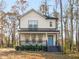 Charming two-story home featuring a welcoming front porch, neutral siding, and a pop of color with its bright blue front door at 741 Se Knox Se Dr, Atlanta, GA 30315