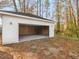 Open garage with concrete floor and a white exterior that blends seamlessly with its wooded, natural surroundings at 741 Se Knox Se Dr, Atlanta, GA 30315