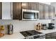 Close-up of a kitchen with stainless steel microwave, gas range, and white backsplash at 949 Tumlin Trce, Lawrenceville, GA 30045