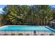 Community pool surrounded by lush trees and a black metal fence at 949 Tumlin Trce, Lawrenceville, GA 30045