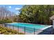 Community pool featuring a diving board and extensive treed landscape surrounding the fenced in area at 949 Tumlin Trce, Lawrenceville, GA 30045