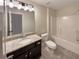 Bathroom featuring a granite countertop, dark cabinets, and a shower-tub combo at 129 Elite Way, Mcdonough, GA 30252