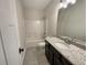 Bathroom featuring a granite countertop, dark cabinets, and a shower-tub combo at 129 Elite Way, Mcdonough, GA 30252