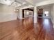 Open-concept living room features hardwood floors, coffered ceilings, and a brick fireplace, flowing into the kitchen at 129 Elite Way, Mcdonough, GA 30252