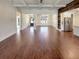 Open-concept living room with hardwood floors, a beamed ceiling, and kitchen with stainless steel refrigerator at 129 Elite Way, Mcdonough, GA 30252