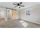 Bright bedroom featuring a ceiling fan, gray walls and a sliding barn door, with gray carpeting throughout at 19 Grove Park Nw Pl, Atlanta, GA 30318