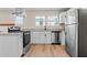 Modern kitchen with stainless steel appliances, granite countertops, and sleek white cabinetry at 19 Grove Park Nw Pl, Atlanta, GA 30318