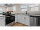 Bright, open kitchen featuring white cabinets, granite countertops, and stainless steel appliances at 19 Grove Park Nw Pl, Atlanta, GA 30318