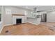 Open-concept space with hardwood floors, a white brick fireplace, and a modern kitchen in view at 19 Grove Park Nw Pl, Atlanta, GA 30318