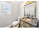 Elegant half bathroom featuring a decorative mirror, sink, toilet and window at 931 New Bedford, Marietta, GA 30068