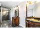 Elegant bathroom features antique vanity cabinets, granite counters, framed mirrors and glass shower at 931 New Bedford, Marietta, GA 30068