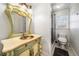 Bathroom vanity with antique gold mirror and copper sink, and a glass-enclosed shower with marble tile at 931 New Bedford, Marietta, GA 30068