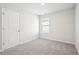 A bright bedroom with a window, plush carpet, and white walls at 2012 Wyndham Pl, Conyers, GA 30013