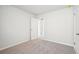 A well-lit bedroom with neutral walls, plush carpeting, and a doorway at 2012 Wyndham Pl, Conyers, GA 30013