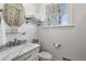 Stylish bathroom featuring a marble vanity top, round mirror and a bright window at 435 Collier Nw Rd, Atlanta, GA 30309