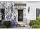 Elegant front door with black hardware, flanked by sconces and lush greenery at 435 Collier Nw Rd, Atlanta, GA 30309