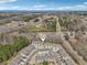 Community aerial view of gray townhomes near a road and surrounded by green trees at 5890 Vinyard Ln, Cumming, GA 30041