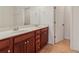 Bathroom with double sink vanity with white countertops and wood cabinets at 5890 Vinyard Ln, Cumming, GA 30041